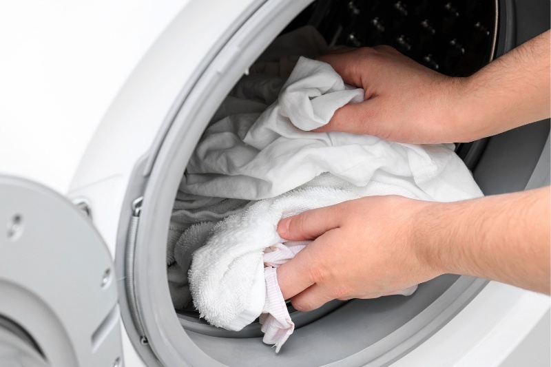putting clothes in washing machine