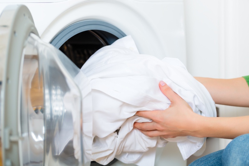 putting dirty laundry in washing machine