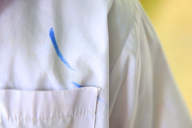 white polo with blue permanent marker stain