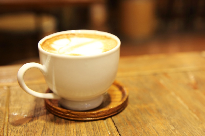 wood table with coffee on coaster