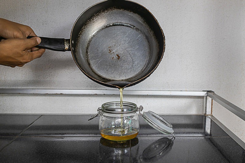 Pouring cooking oil into a jar