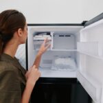 Woman opening freezer door
