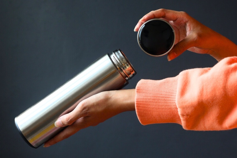 hand holding a stainless steel flask