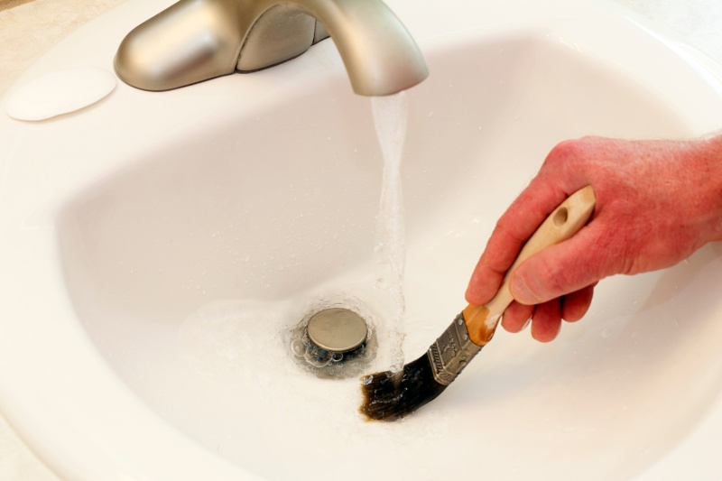 rinsing paint brush in the sink