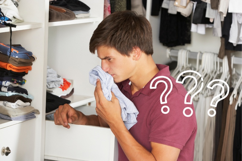 man smelling clothes in the wardrobe