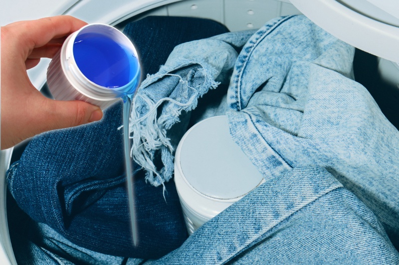 pouring laundry detergent in the washing machine
