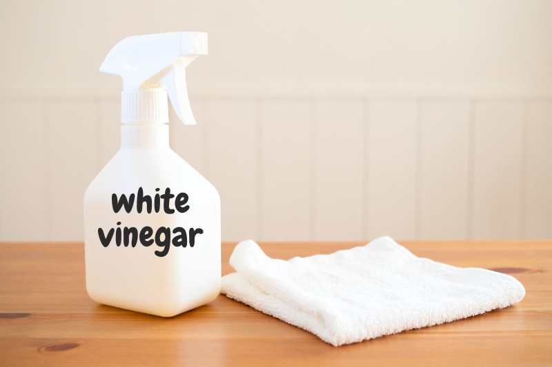 white vinegar and cloth on wooden table