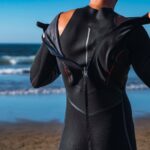 How to Wash a Wetsuit woman wearing wetsuit in the beach
