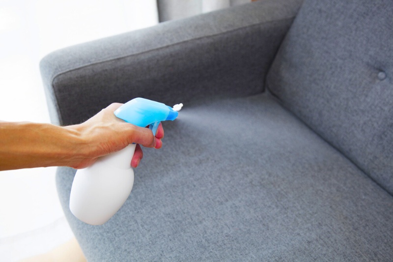 fabric freshener spray on gray couch