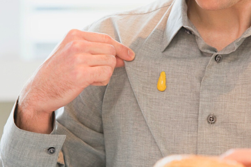 mustard stain on man's polo top