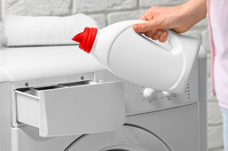 pouring fabric softener in the washing machine drawer