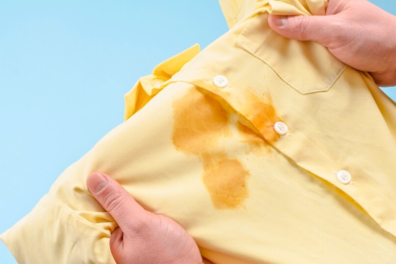 stain on yellow polo top