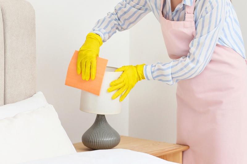 woman cleaning lampshade