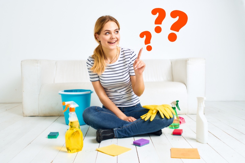 woman pointing up and surrounded with cleaning supplies