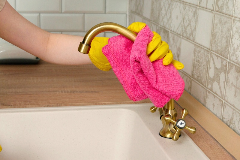 wiping brass tap with cloth